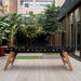 RS Barcelona RS MAX outdoor dining football table with glass top and wooden legs positioned in a modern garden patio setting.