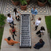 Overhead view of RS Barcelona RS Max football table with players gathered around in outdoor patio, modern foosball table with wooden handles and sleek black design for social gaming.