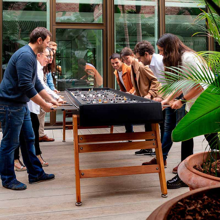 Players gathered around the RS Barcelona RS MAX football table enjoying a competitive game on a premium outdoor designer foosball table.