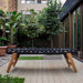 Side view of the RS Barcelona RS MAX football table featuring a sleek black body, wooden legs and handles, a modern outdoor foosball table for gardens and terraces.