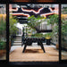 Black RS Barcelona RS2 dining football table in stylish indoor garden setting with glass top, blending foosball gameplay and contemporary dining furniture design.