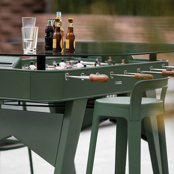RS Barcelona RS2 dining football table in green with glass dining top used outdoors, stylish foosball dining table with drinks and glasses on modern outdoor patio.