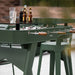 RS Barcelona RS2 dining football table in green with glass dining top used outdoors, stylish foosball dining table with drinks and glasses on modern outdoor patio.
