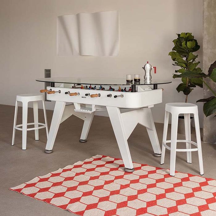 White RS Barcelona RS2 dining football table with glass top styled in a modern interior, multifunctional foosball dining table with stools and contemporary décor.