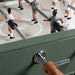 Detail view of RS Barcelona RS2 football table with green frame, wooden handles and classic foosball player figures.