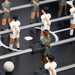 Close-up of RS Barcelona RS2 football table players and rods on a dark pitch with white foosball.