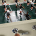 Close-up of RS Barcelona RS2 football table player figures on stainless steel rods and green pitch, highlighting premium foosball table craftsmanship.