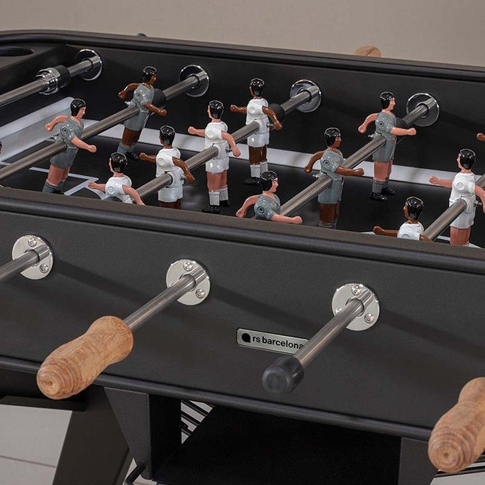 Detailed view of RS Barcelona RS2 football table player figures on the pitch showing classic foosball gameplay design.