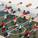 Close-up of RS Barcelona RS2 football table player figures on green pitch with stainless steel rods and white foosball.