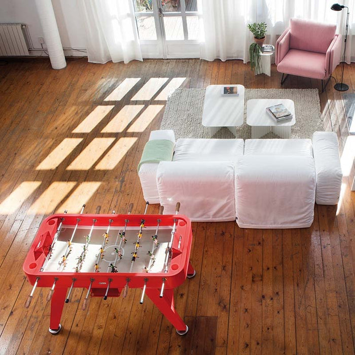 RS Barcelona RS2 football table in red finish placed in a bright modern living room with wooden flooring.