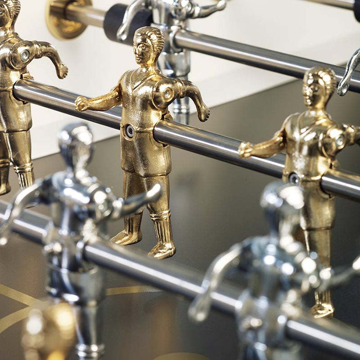 Close-up of RS Barcelona RS2 Gold football table player figures in gold and silver on stainless steel rods, showcasing premium foosball table craftsmanship.