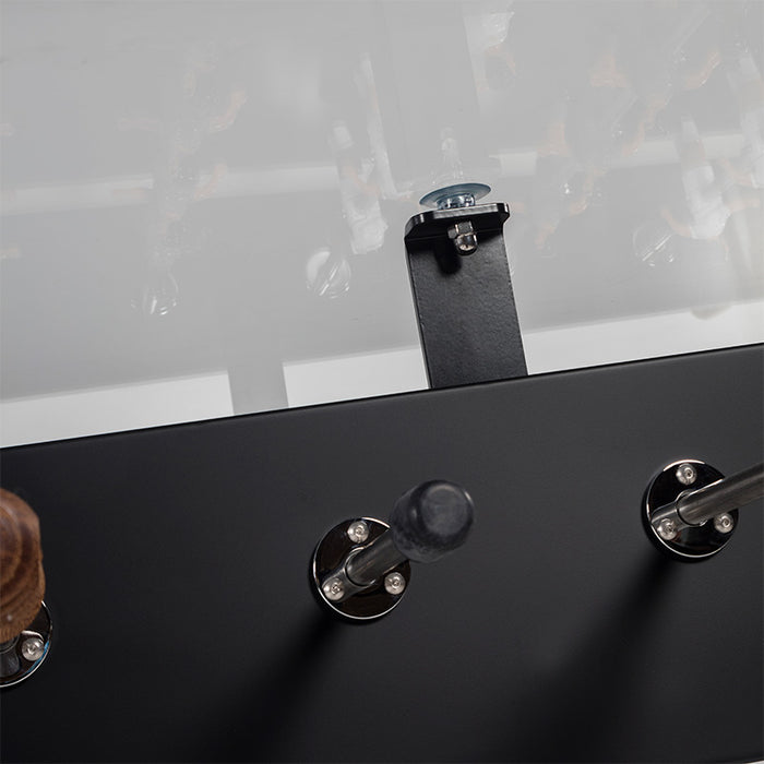 Close-up detail of RS Barcelona RS3 dining football table glass top support bracket and foosball handles on matte black frame.