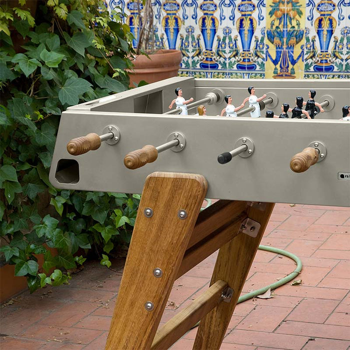 Close-up of RS Barcelona RS3 Wood football table corner with wooden legs and handles, detailed craftsmanship of outdoor foosball table with premium materials.
