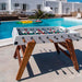 RS Barcelona RS3 Wood football table in outdoor poolside setting with white frame and solid wooden legs, premium outdoor foosball table with modern design and luxury leisure lifestyle.