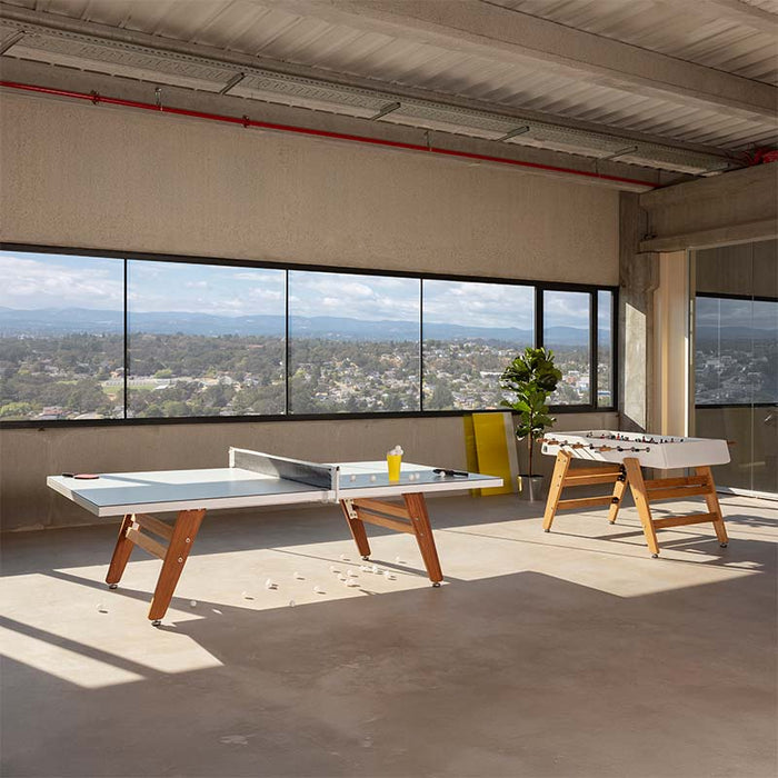 RS Barcelona RS3 Wood football table and ping pong table in minimalist indoor space with natural light, wooden legs and modern design for leisure and entertainment areas.