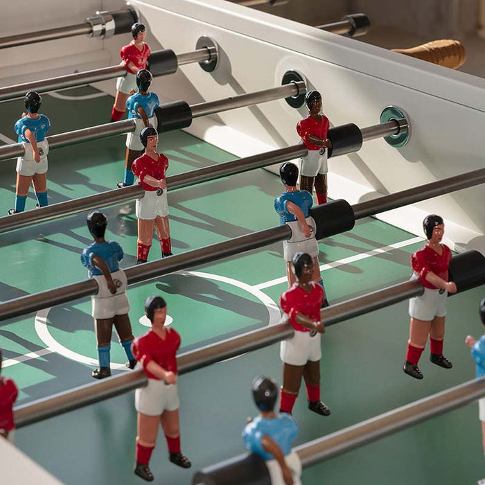 Close-up of RS Barcelona RS3 Wood football table players on a green foosball pitch showing detailed football figures and smooth steel rods.