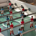 Close-up of RS Barcelona RS3 Wood football table players on a green foosball pitch showing detailed football figures and smooth steel rods.