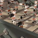 Detailed view of RS Barcelona RS3 Wood football table player figures on a minimalist grey pitch with precision rods and modern foosball design.