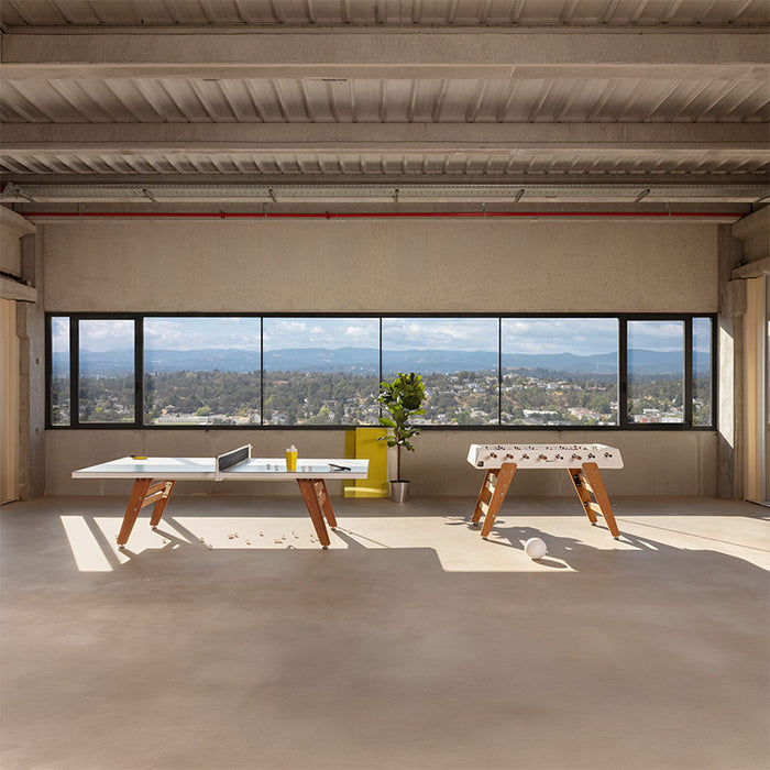 RS Barcelona RS3 Wood football table and table tennis setup in bright open interior with panoramic window views, multifunctional gaming furniture with contemporary style.