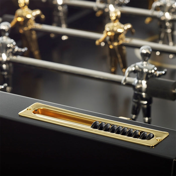 RS Barcelona RS3 Wood Gold football table ball return tray with brass finish and black scoring beads beneath chrome foosball rods and metallic players.