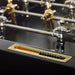 RS Barcelona RS3 Wood Gold football table ball return tray with brass finish and black scoring beads beneath chrome foosball rods and metallic players.