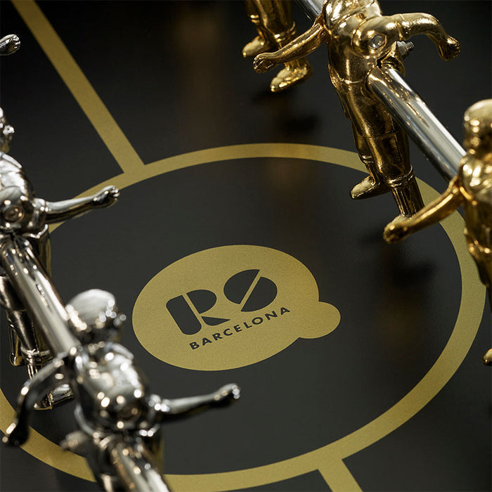 Detail of RS Barcelona RS3 Wood Gold football table pitch with gold centre circle, RS Barcelona logo and metallic foosball players on a luxury designer table football game.
