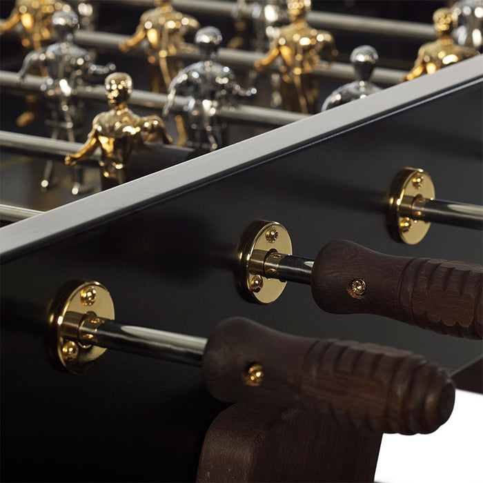 Side detail of RS Barcelona RS3 Wood Gold football table featuring carved wooden handles, polished rods and brass mounting plates on a premium foosball table.