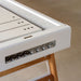 Front view of RS Barcelona Track shuffleboard table in white with wooden legs and integrated metal puck storage.