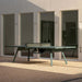 RS Barcelona You and Me monochrome ping pong table in green finish with net, modern outdoor table tennis table with clean lines and architectural backdrop.