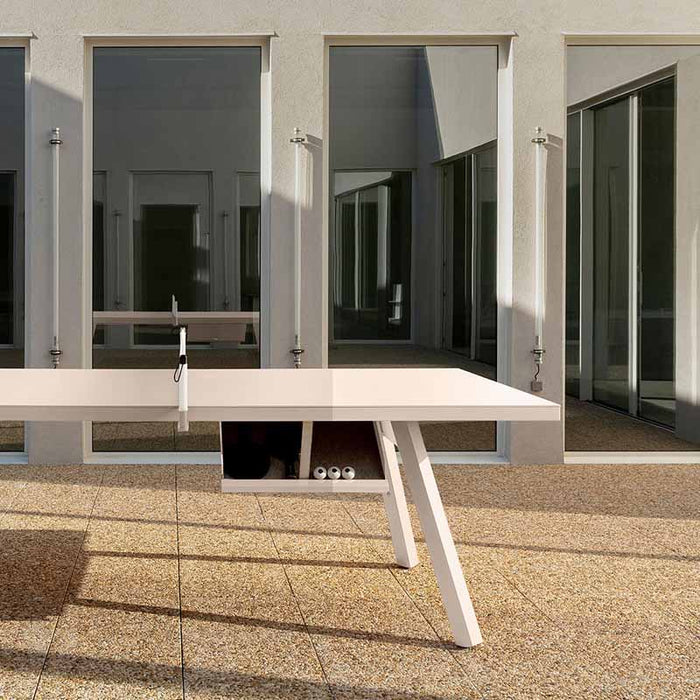 RS Barcelona You and Me monochrome ping pong table in bright red with net and paddles, modern outdoor table tennis table in minimalist architectural courtyard.