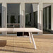 RS Barcelona You and Me monochrome ping pong table in bright red with net and paddles, modern outdoor table tennis table in minimalist architectural courtyard.
