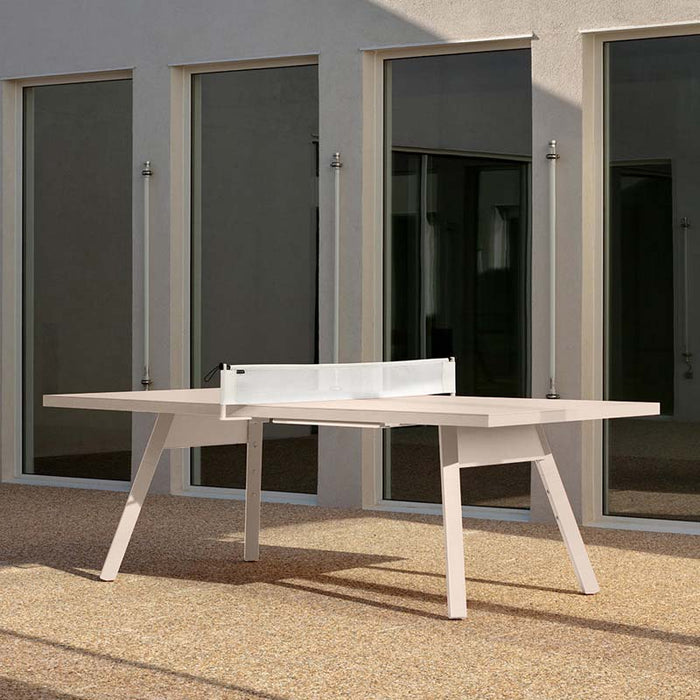 RS Barcelona You and Me monochrome ping pong table in blue with paddles on surface, contemporary outdoor table tennis table in minimalist courtyard setting.