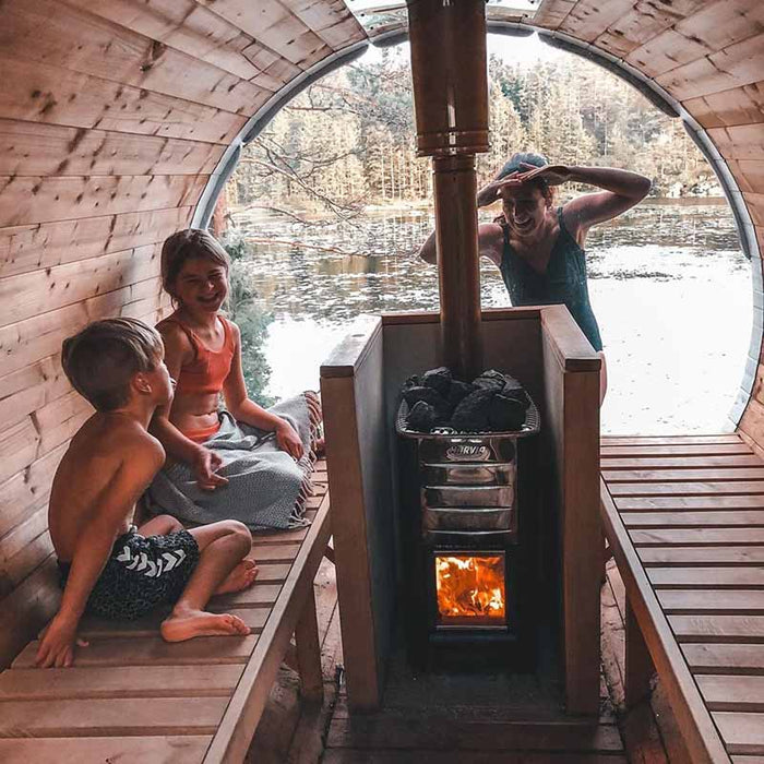 Family enjoying Sauna Barrel from Thermowood 1.9 x 2m next to a lake.