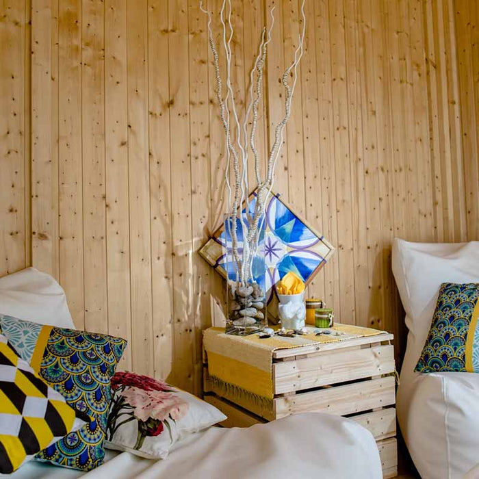 Close-up of decorative cushions and wooden decor inside of Traditional Sauna Cube.