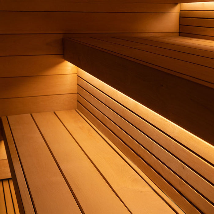 Close-up of the Saunum AirCube Space Outdoor Sauna interior, showcasing elegant Thermo-Aspen wood benches with integrated LED lighting for a luxurious sauna experience.