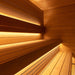 Detailed view of the wooden benches and soft, under-bench lighting inside the Saunum AirCube Terrace Outdoor Sauna, enhancing the warm ambiance.