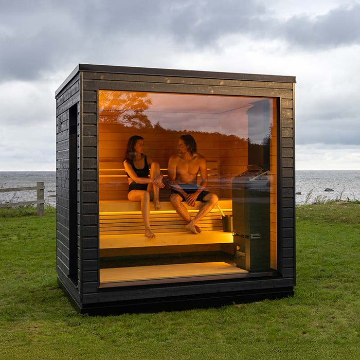 Saunum Classic Outdoor Sauna, 4 Person capacity, exterior view displaying its modern design with full glass doors and premium wood cladding.