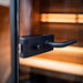 Close-up of the modern black handle and lock on the Saunum Classic Mini Outdoor Sauna's tempered glass door, offering both style and security for your sauna experience.