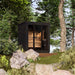 Saunum Classic Mini Outdoor Sauna nestled in a natural setting with rocks and greenery, blending contemporary design with the outdoor environment for a luxurious wellness experience.