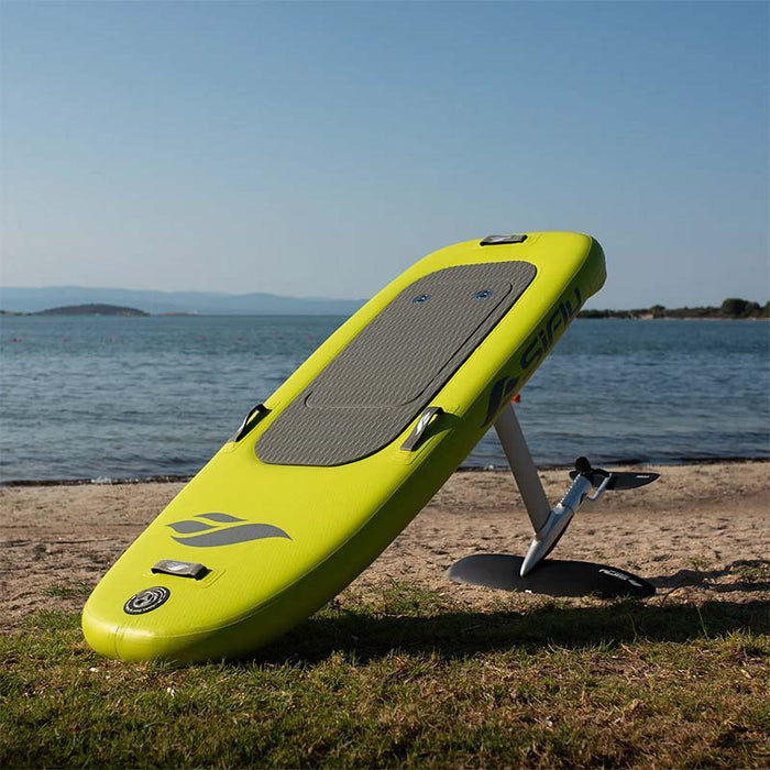 Yellow SiFly Lite eFoil Set resting on grass beside the water.