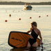 Woman holding the SiFly Rider eFoil Set and remote controller in the water.