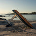 SiFly Stellar blue eFoil Set displayed on a sandy beach with wood-effect deck, mast, motor and hydrofoil wings.