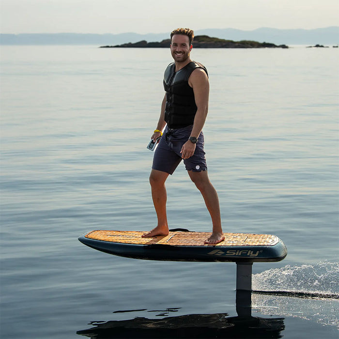 Rider standing on a SiFly Stellar electric foil board while cruising smoothly above calm open water.
