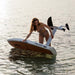 SiFly Stellar white eFoil board being handled in shallow water, showing the hydrofoil mast, motor and wings.