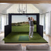 Golfer completing a swing on the Simbooth 1 Golf Simulator Kit in a bright, elegant living room setup, displaying immersive course graphics and real-time feedback.