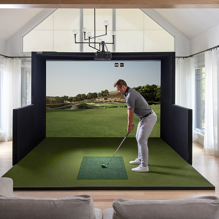 Man preparing to take a shot on the Simbooth 1 Golf Simulator Kit in a home lounge, showing vivid golf course imagery and a realistic tee-off experience.