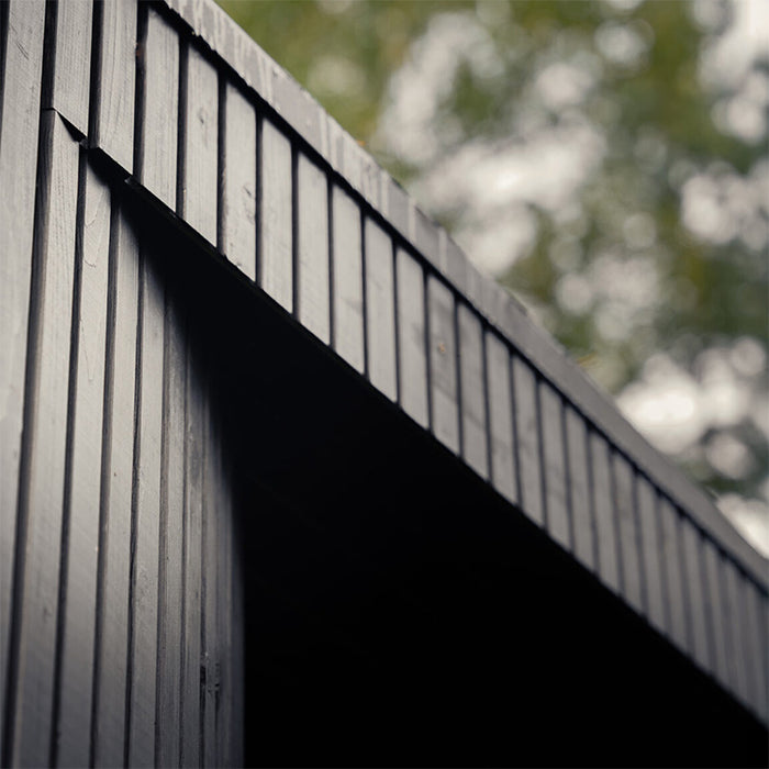 Close-up of the exterior vertical black timber cladding on the Tauras Classic sauna with hot tub, emphasising premium outdoor sauna construction.