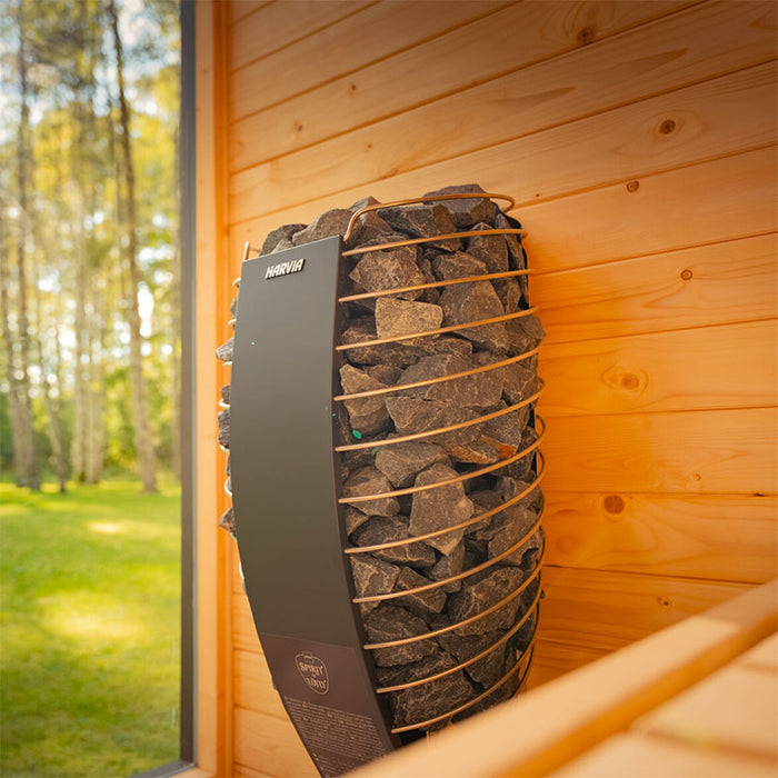 Interior view of the Tauras Classic sauna showing the Harvia electric heater with lava stones, designed for efficient heat distribution and authentic sauna steam.
