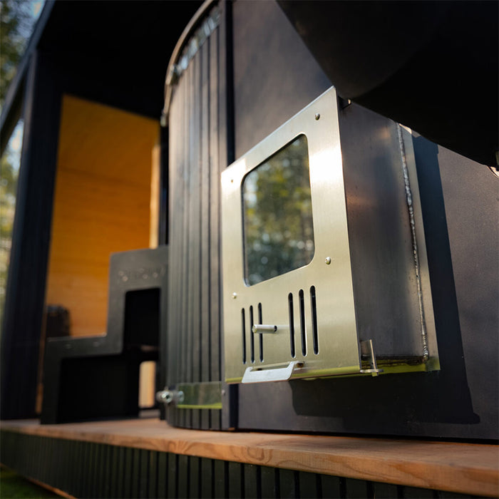 Detailed view of the metal stove and firebox used to heat the Tauras Classic outdoor hot tub, showcasing its efficient wood-fired heating system.