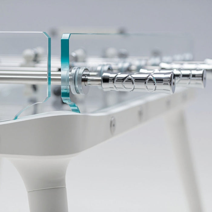 A close-up of the chrome handles of the foosball table, highlighting their intricate design and polished finish